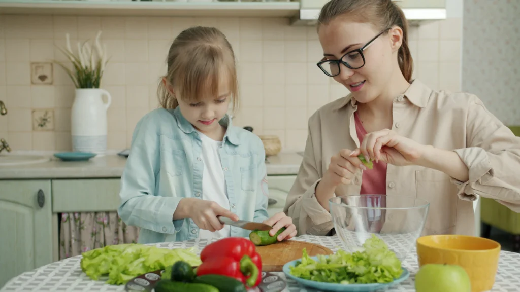 Nutrição infantil: mãe e filha a preparar uma salada saudável