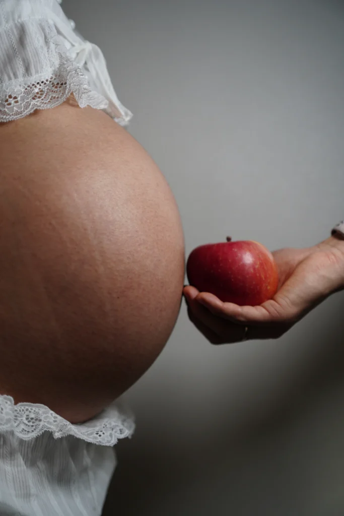 Nutrição na gravidez: grávida com uma maçã, símbolo de alimentação saudável