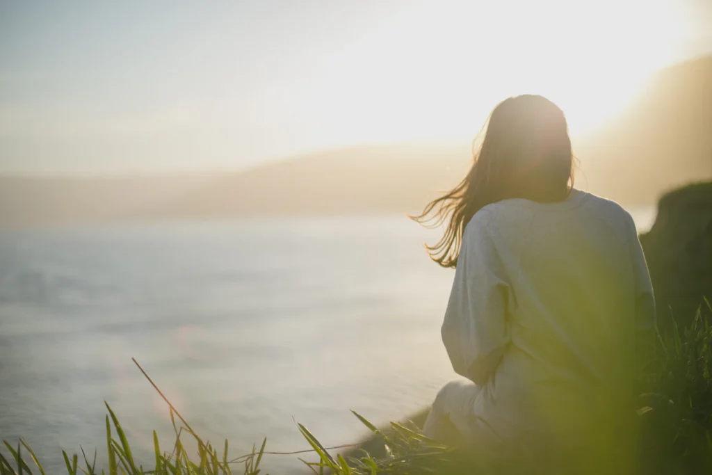 Pessoa a contemplar o mar com tranquilidade: saúde mental e bem-estar