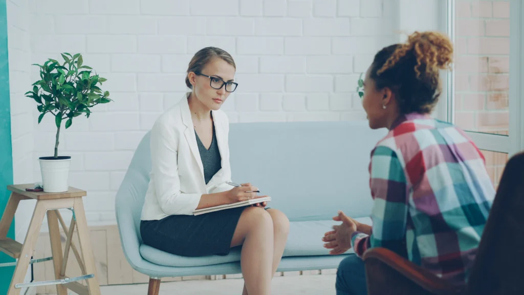 Consulta de psicologia clínica: psicóloga a conversar com uma jovem